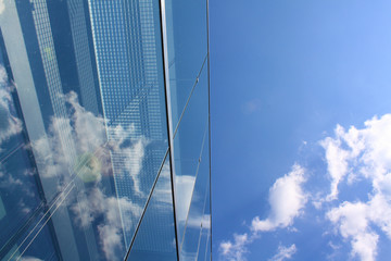 Fototapeta na wymiar Modern glass office building reflecting the clouds