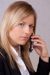 Concentrated business woman with mobile phone - obrazy, fototapety, plakaty