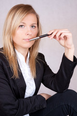 Beautiful business woman with ballpen in mouth