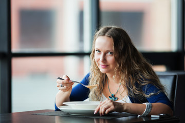 Young woman eating soup.