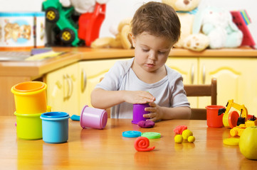 Little child playing plasticine