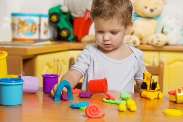 Little child playing plasticine