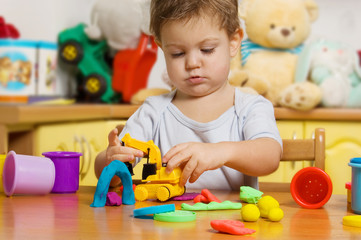 Little child playing plasticine