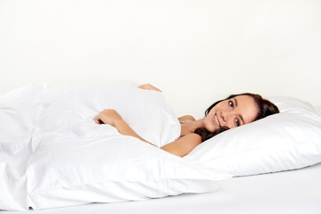 Fototapeta na wymiar lächelnde junge Frau im Bett