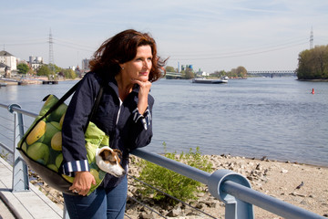 Frau nachdenklich ans Geländer lehnend