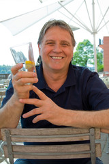 Mann sitzt trinkend im Lokal