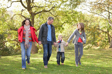 Young Family Outdoors Walking Through Park