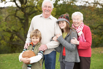 Fototapeta premium Grandparents With Grandchildren Holding Football Outside