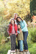 Family Group Standing Outdoors On Wooden Walkway In Autumn Lands
