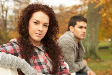 Fototapeta premium Close Up Of Teenage Couple Sitting On Bench In Autumn Park