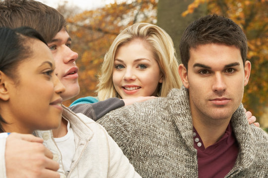 Close Up Of Group Of Four Teenage Friends In Autumn Woodland