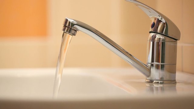 Man's hand starting and stopping tap water