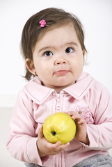 Silky baby holding an apple - obrazy, fototapety, plakaty