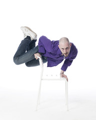 jeune homme en équilibre sur une chaise © STUDIO GRAND WEB