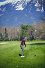Woman golfer ready for a swing on a green field