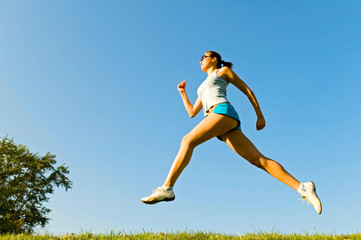 Fototapeta premium young woman running on the grass