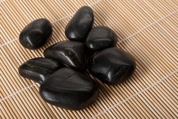 Fototapeta na wymiar Some dark brilliant stones lie on mat