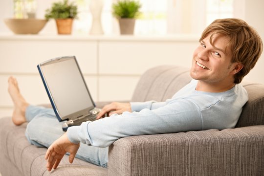 Man with computer on sofa