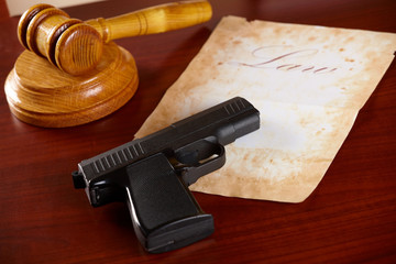 Judges gavel with gun and very old paper