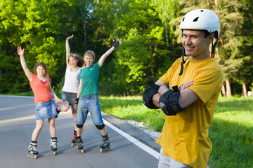 Group of men and women on rollerblades having fun at park