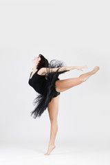 Beautiful ballerina doing split against white background