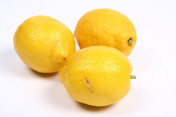 Three ripe yellow lemons on white background