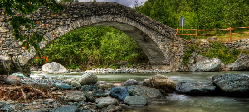 Ponte romano su torrente di pietre in alta montagna