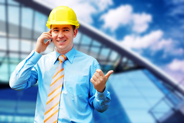 Young architect wearing a protective helmet standing on the buil