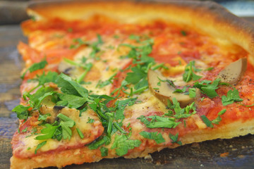 Piece of pizza with salami and vegetables