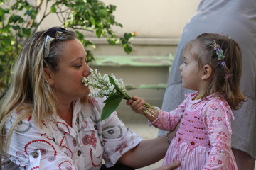 petite fille offrant des fleurs à sa mère