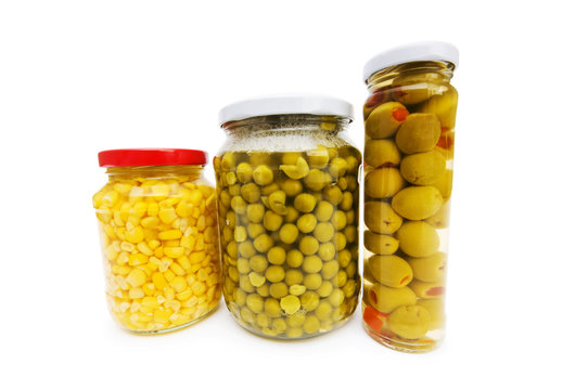 Various pickles in the glass jars on white
