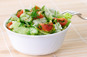 Fresh vegetable salad with tomato, lettuce, cucumber.