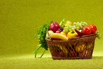 basket full of fresh produce. green background