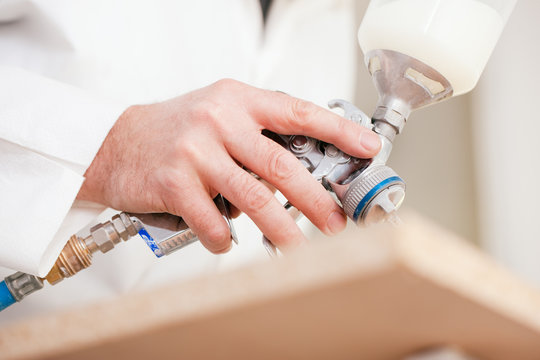 Tischler lackiert ein Werkst&uuml;ck