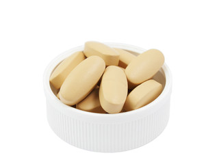 Multivitamin pills in the white plastic cap isolated on white
