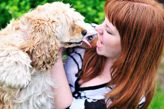 redheaded girl having fun with her dog