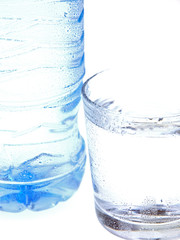 bottle and glass of mineral water on white background