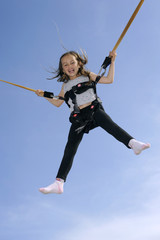 Young girl playing on bungee trampoline