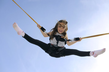 Young girl playing on bungee trampoline