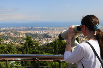 Fototapeta na wymiar Woman looking through a coin operated binoculars