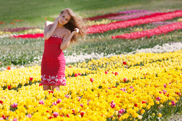 young beautiful girl in yellow and red tulips