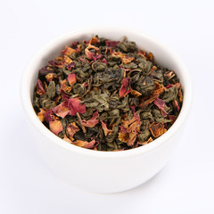 Bowl filled with dried green tea leaves and rose petals on white