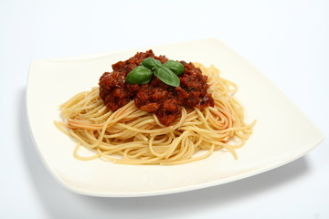 Pasta with bolognese sauce on a plate  with fresh basil