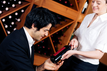Kellnerin bietet eine Flasche Rotwein an