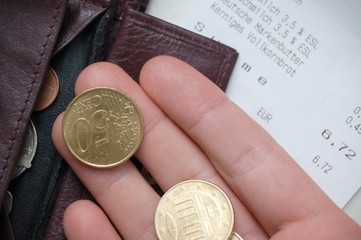 Hand mit Geld, Kassenbon und Geldbörse