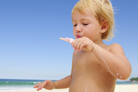 Summer Vacation: Child Eating Icecream On The Beach