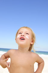 cute child with sunscreen  at the beach