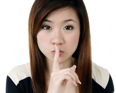 Attractive young woman with finger on her lips