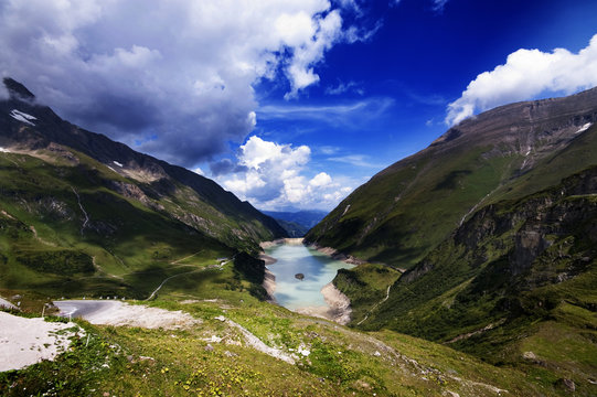 mountain lake between some mountains with clouds