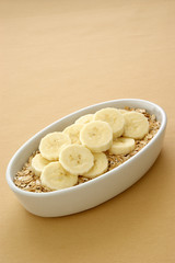 Müsli mit Bananenscheiben in einer weissen Schale